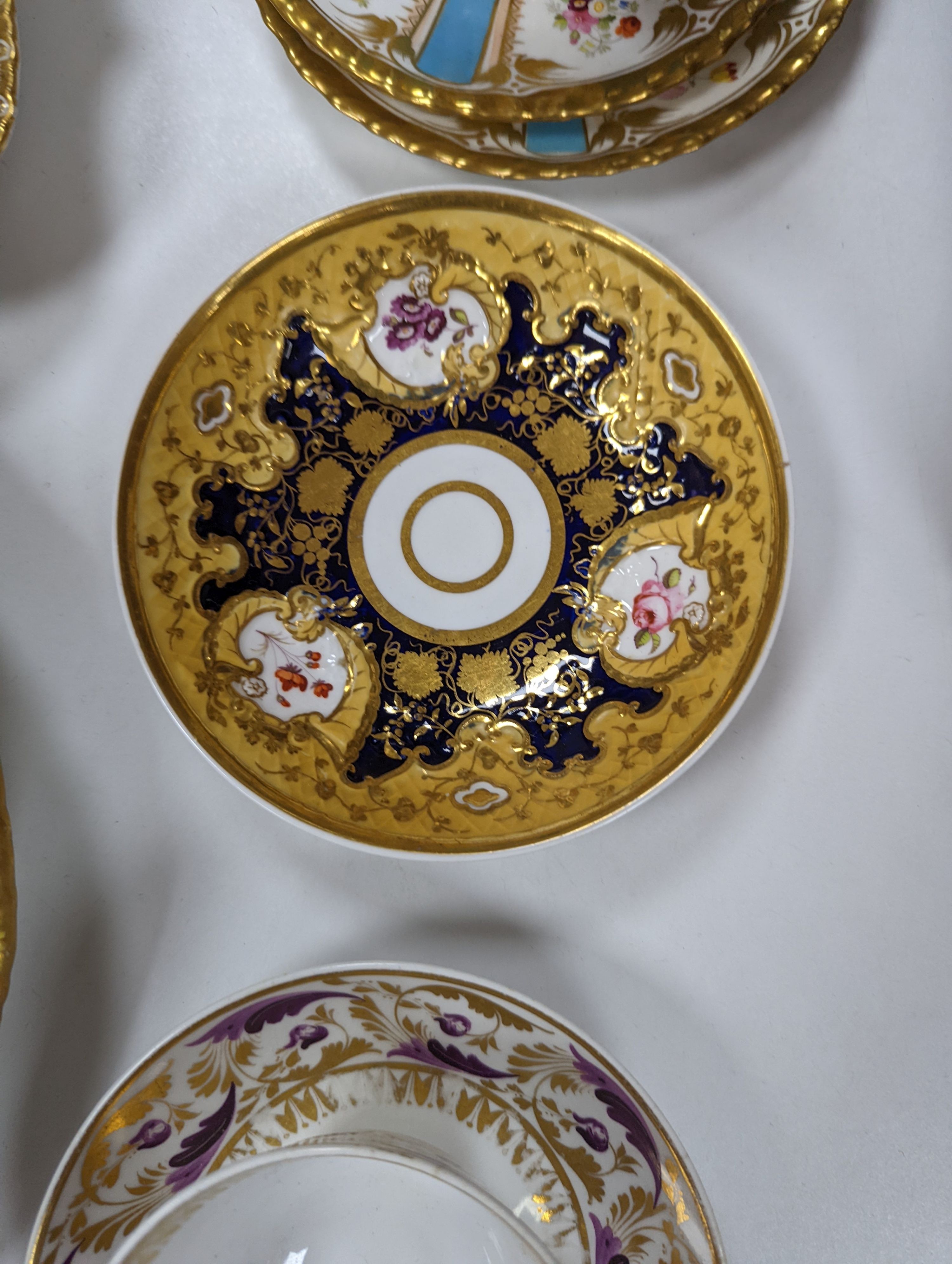 A small collection of Victorian porcelain tea cups and saucers and sundry dessert plates